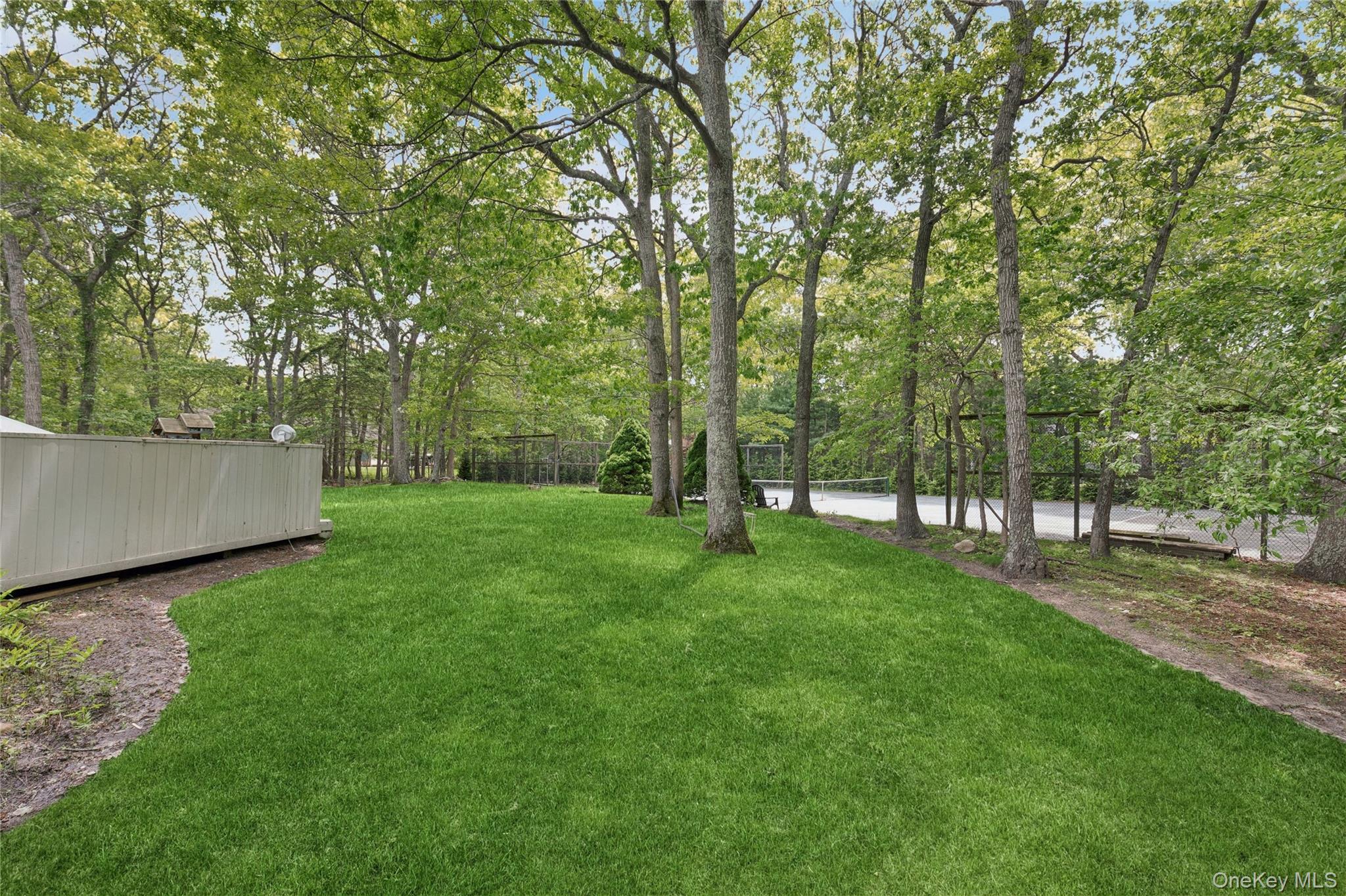 18 Quail Run Hampton Bays, NY 11946 - Photo 11 of 44 a view of a backyard with large trees