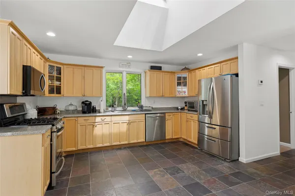 a kitchen with a sink stainless steel appliances furniture cabinets and a large window