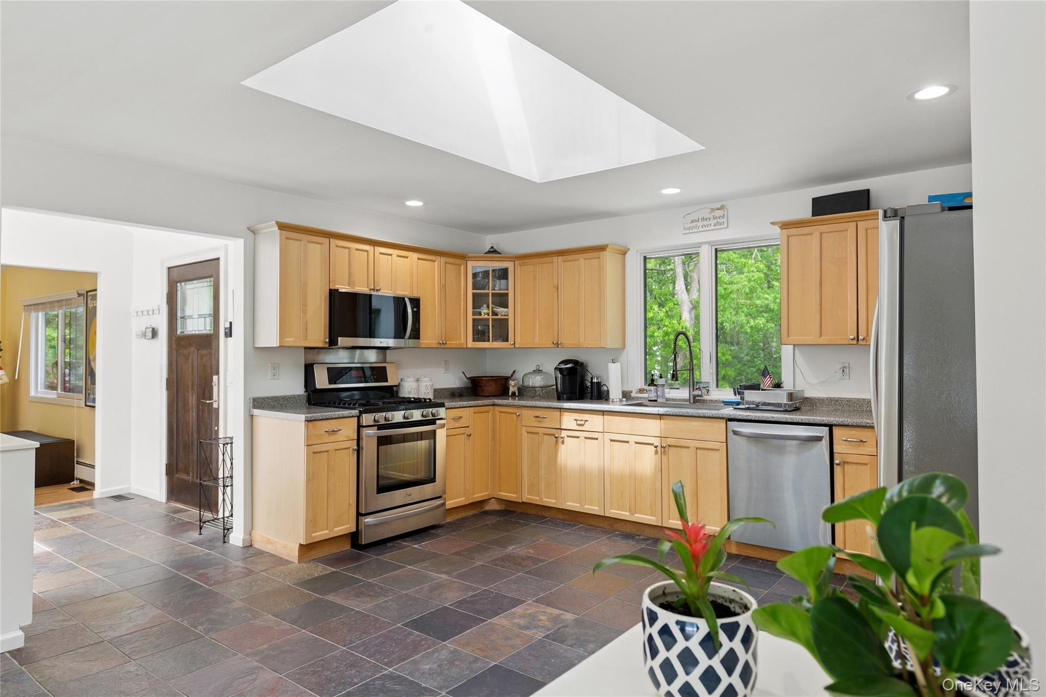 18 Quail Run Hampton Bays, NY 11946 - Photo 22 of 44 a kitchen with a sink stainless steel appliances furniture cabinets and a large window