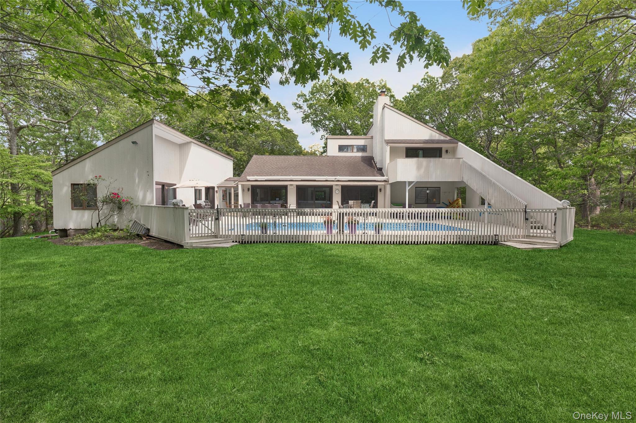 18 Quail Run Hampton Bays, NY 11946 - Photo 3 of 44 a front view of a house with a yard table and chairs
