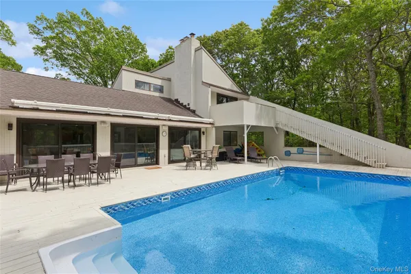 a view of a white house with swimming pool in front of it