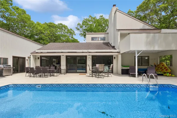 a view of house with yard and sitting area