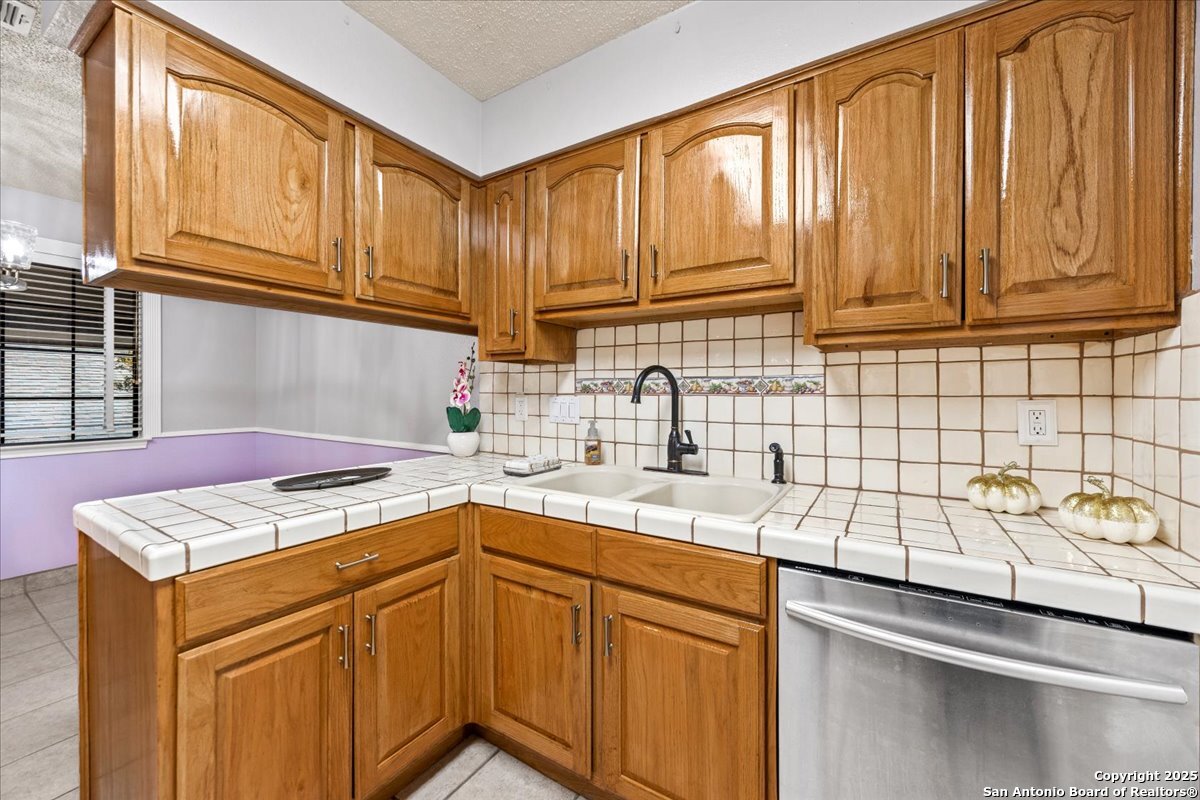 9308 Dover Ridge San Antonio, TX 78250 - Photo 14 of 41 a kitchen with stainless steel appliances granite countertop a sink stove and cabinets