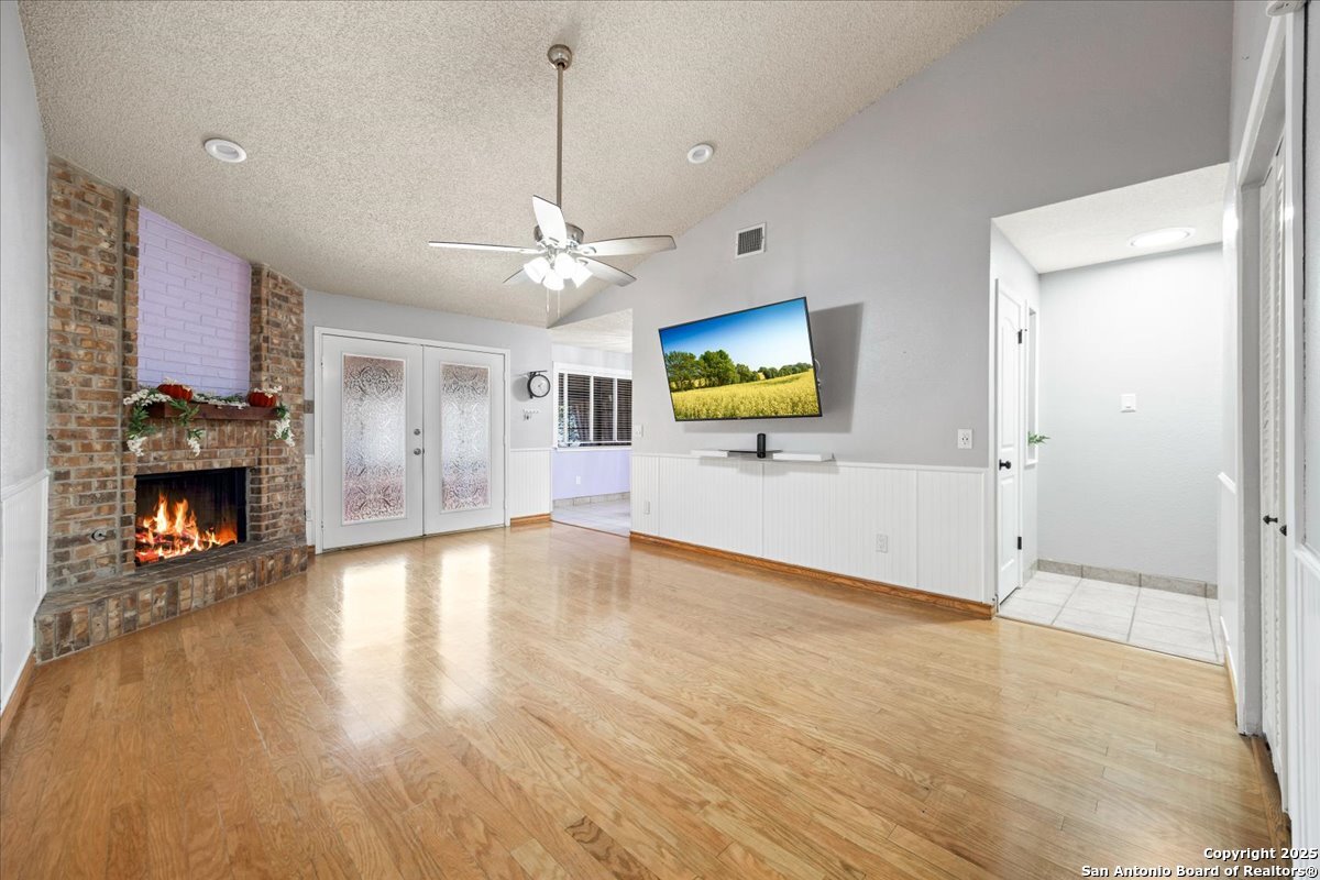 9308 Dover Ridge San Antonio, TX 78250 - Photo 5 of 41 a view of a livingroom with a fireplace a flat screen tv and wooden floor