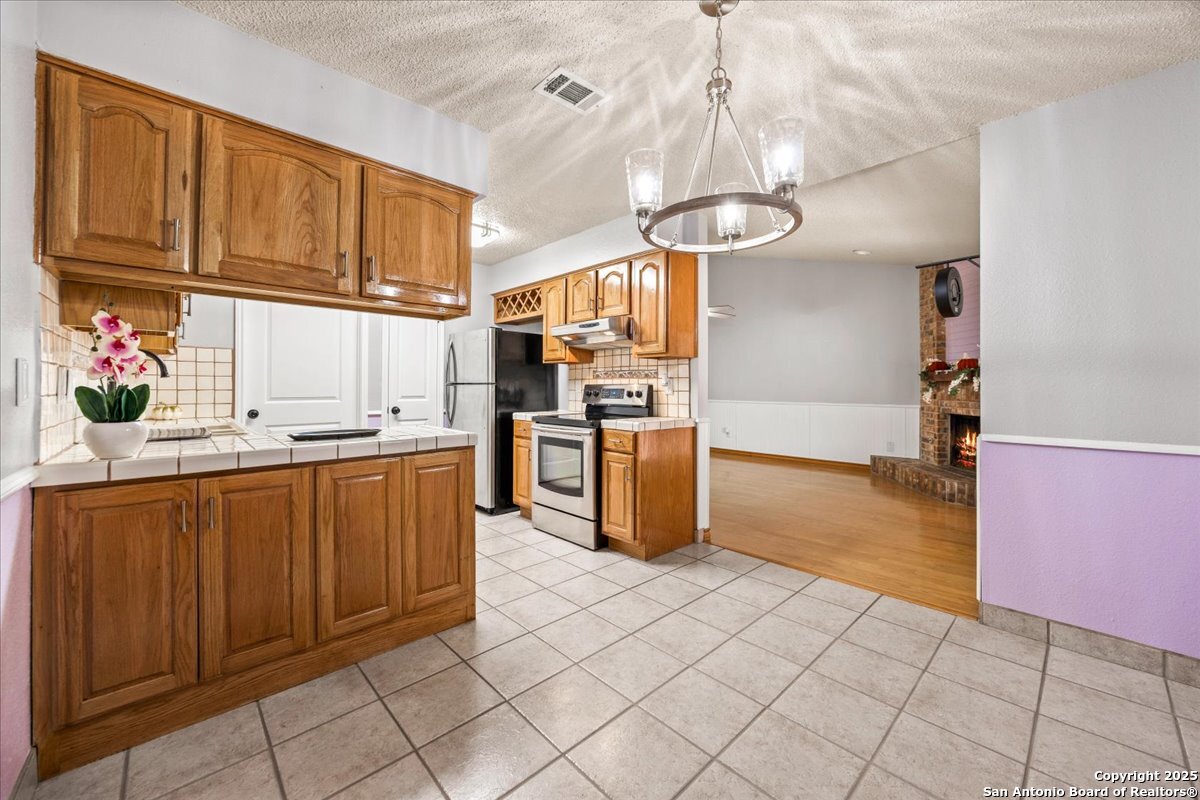 9308 Dover Ridge San Antonio, TX 78250 - Photo 10 of 41 a kitchen with stainless steel appliances granite countertop a sink a stove and refrigerator