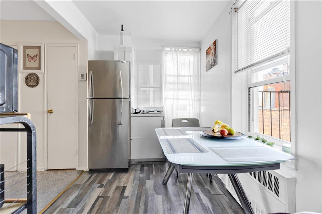 2155 82nd Street, Unit 5D Brooklyn, NY 11214 - Photo 8 of 19 a kitchen with stainless steel appliances a refrigerator a sink a dining table and chairs
