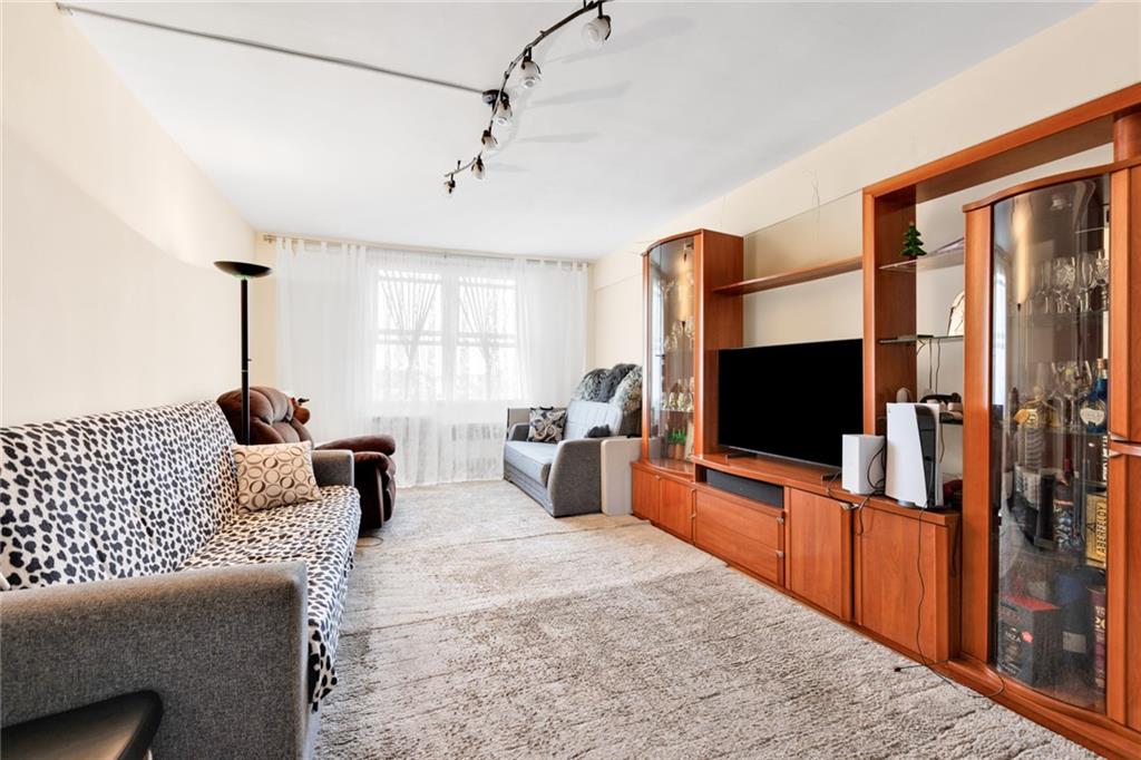 2155 82nd Street, Unit 5D Brooklyn, NY 11214 - Photo 9 of 19 a living room with furniture and a flat screen tv