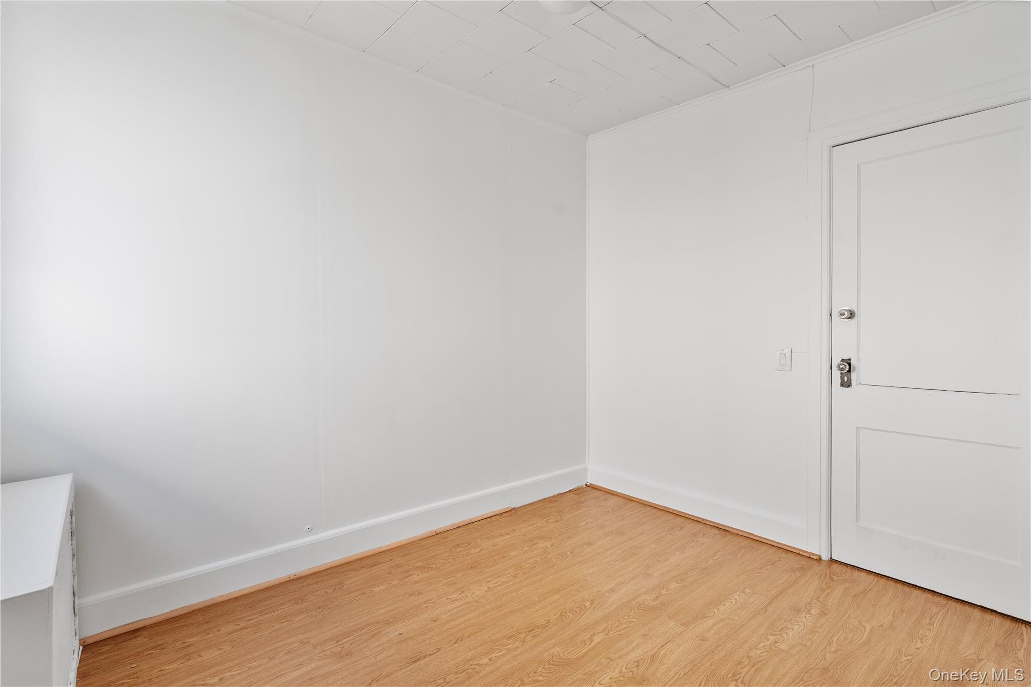 123-10 25th Road Queens, NY 11354 - Photo 18 of 27 Spare room featuring light wood-style floors and baseboards