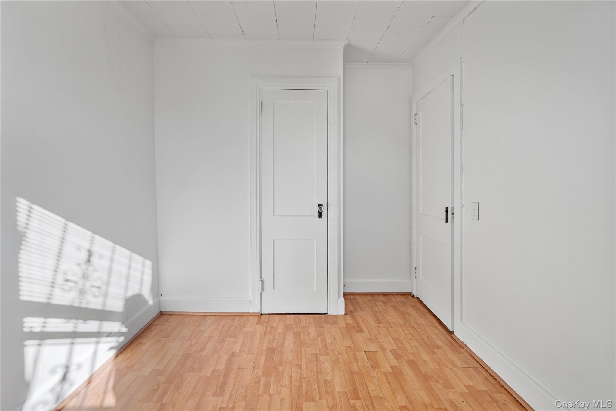 123-10 25th Road Queens, NY 11354 - Photo 20 of 27 Spare room featuring light wood-style floors and baseboards