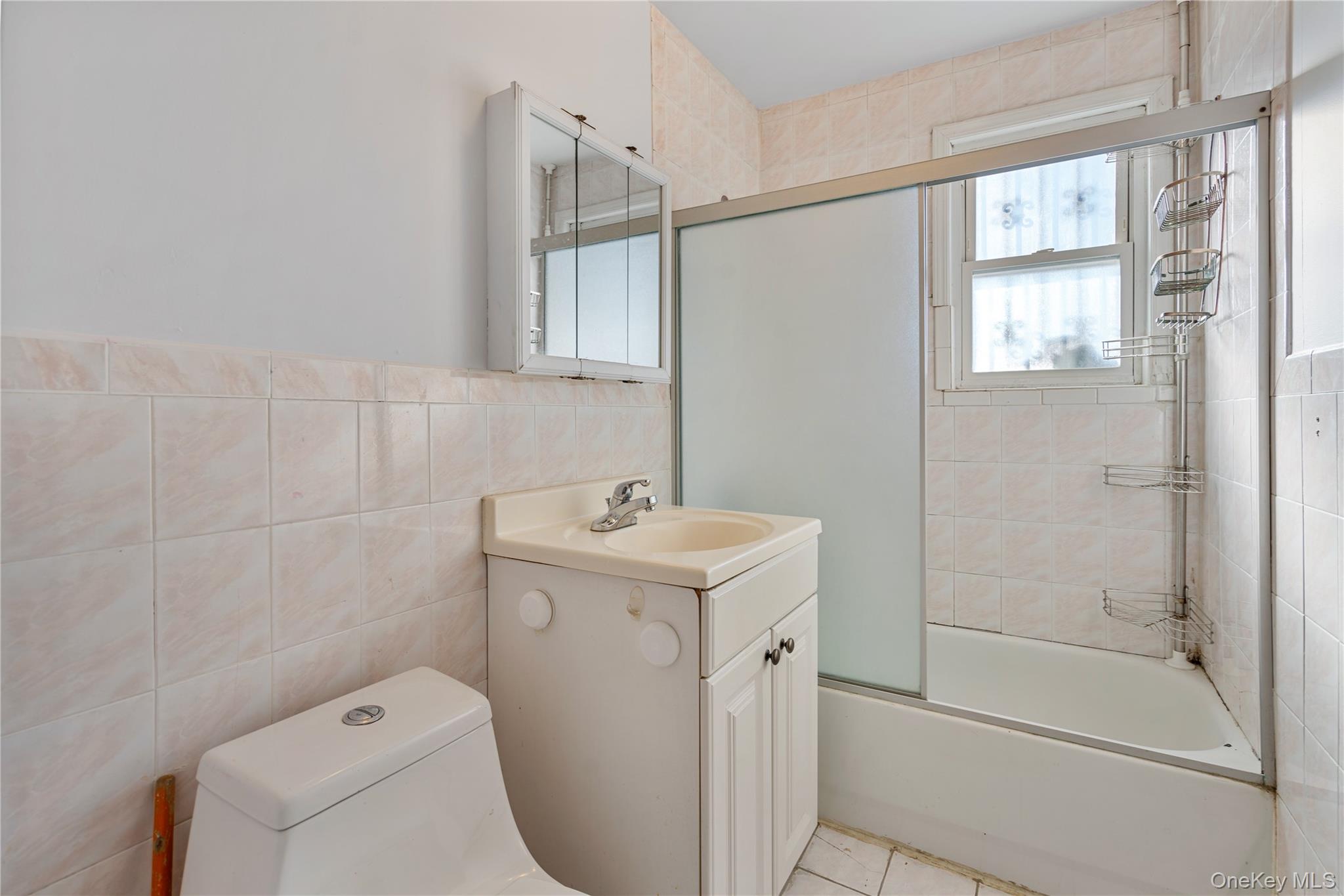 123-10 25th Road Queens, NY 11354 - Photo 21 of 27 Bathroom with vanity, tile walls, and shower / bath combination with glass door