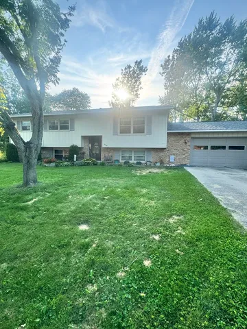 a view of a house with a yard and sitting area