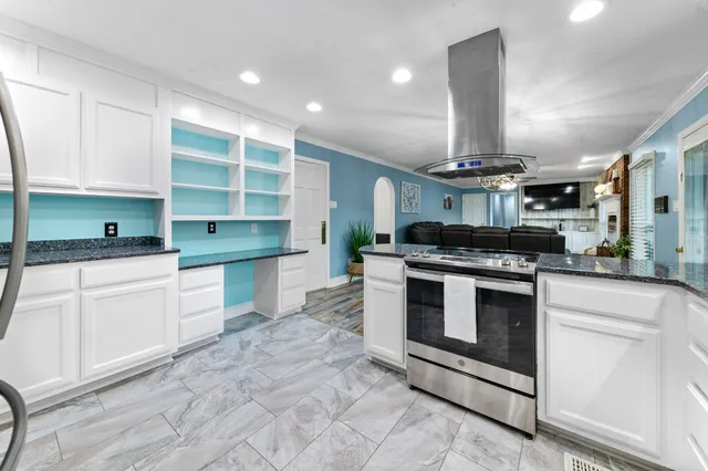 a kitchen with stainless steel appliances kitchen island granite countertop a table chairs sink and cabinets