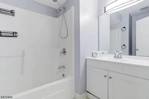 a bathroom with a sink a mirror a shower and a bathtub