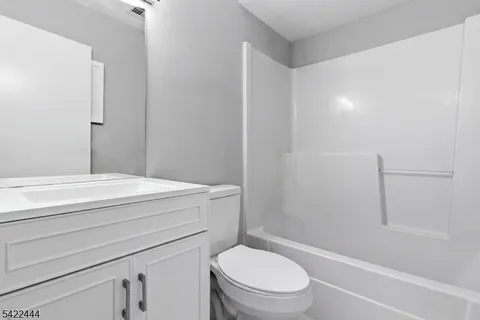 a bathroom with a granite countertop toilet a sink and a bathtub