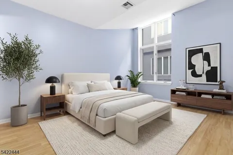 a spacious bedroom with a bed a couch and a potted plant