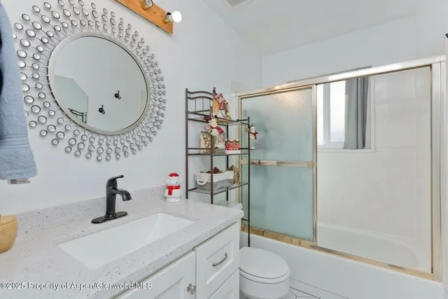 a bathroom with a sink mirror vanity and toilet