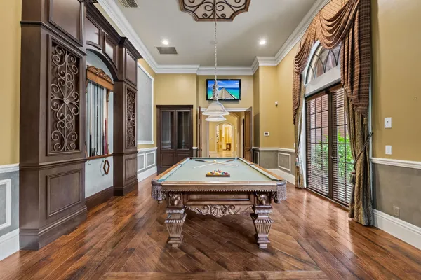 an empty room with chandelier fan and windows
