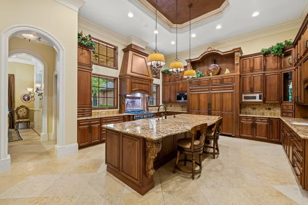a living room with stainless steel appliances kitchen island granite countertop wooden floors a stove and a microwave