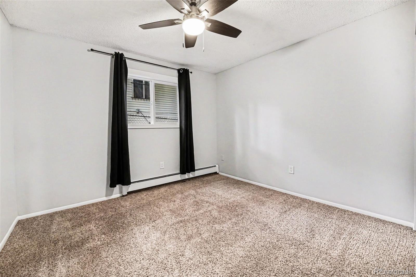 5700 West 28th Avenue, Unit 1 Wheat Ridge, CO 80214 - Photo 12 of 25 an empty room with closet and a chandelier fan