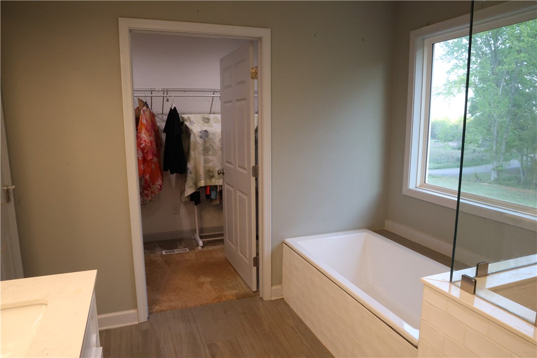 5381 Olden Porter Road Pendleton, SC 29670 - Photo 18 of 31 This primary bathroom offers a pristine soaking tub and a spacious walk-in closet for ultimate comfort.