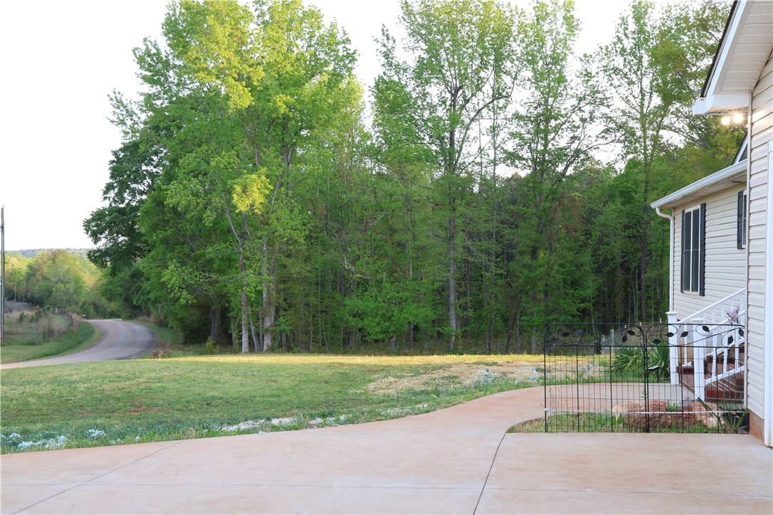 5381 Olden Porter Road Pendleton, SC 29670 - Photo 2 of 31 This tranquil setting offers a concrete driveway leading to a welcoming residence surrounded by lush trees.