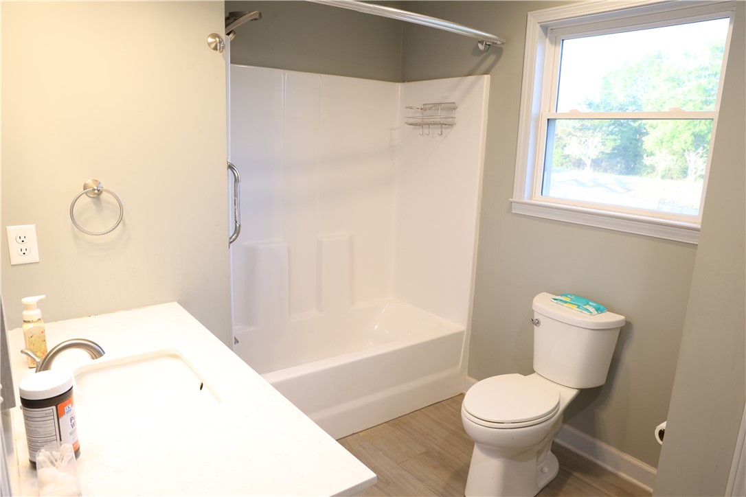 5381 Olden Porter Road Pendleton, SC 29670 - Photo 27 of 31 A well-lit bathroom features a modern vanity, a clean tub-shower combination, and a window.