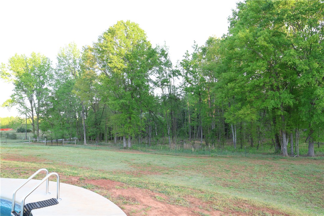5381 Olden Porter Road Pendleton, SC 29670 - Photo 10 of 31 This expansive backyard offers ample space, a refreshing pool, and mature trees for privacy.