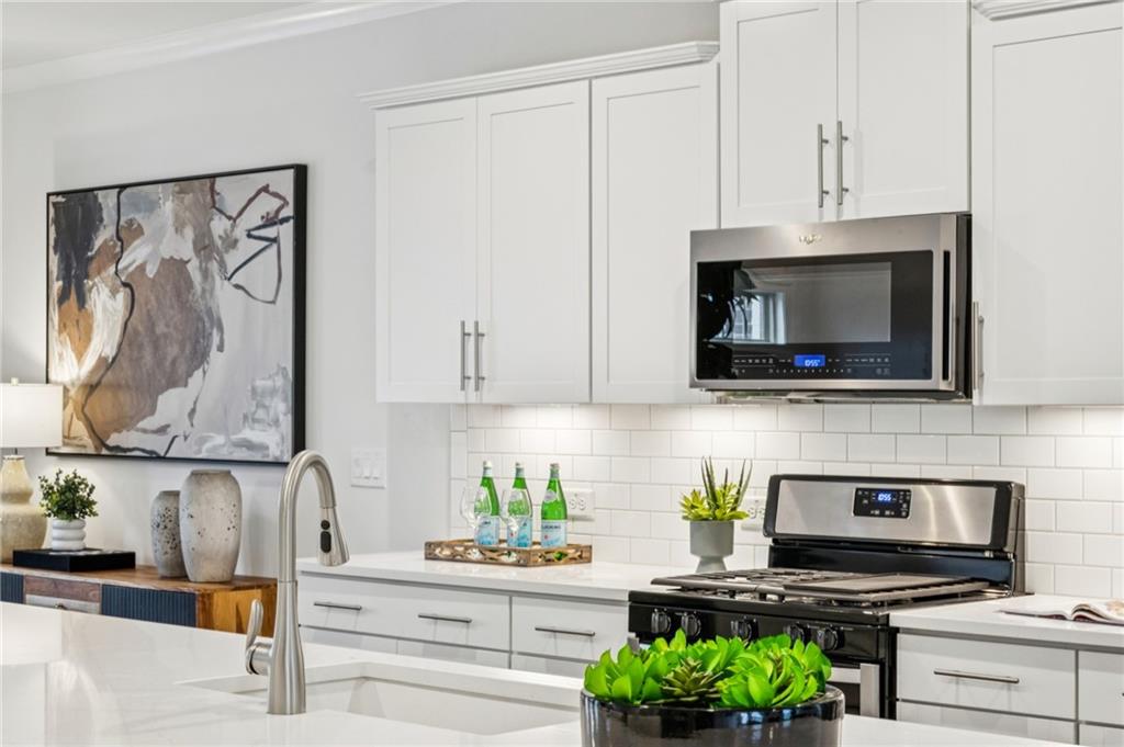 1155 Millennium Park Road Decatur, GA 30033 - Photo 24 of 81 a kitchen with stainless steel appliances kitchen island granite countertop a stove a sink and a microwave