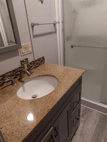 a bathroom with a granite countertop sink and mirror