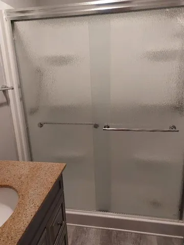 a bathroom with a granite countertop shower and a sink