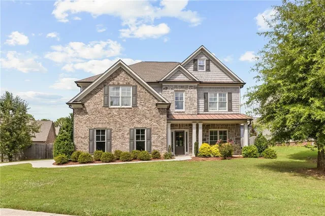 a front view of a house with a yard and trees