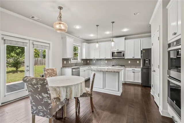 a kitchen with kitchen island granite countertop a center island and appliances