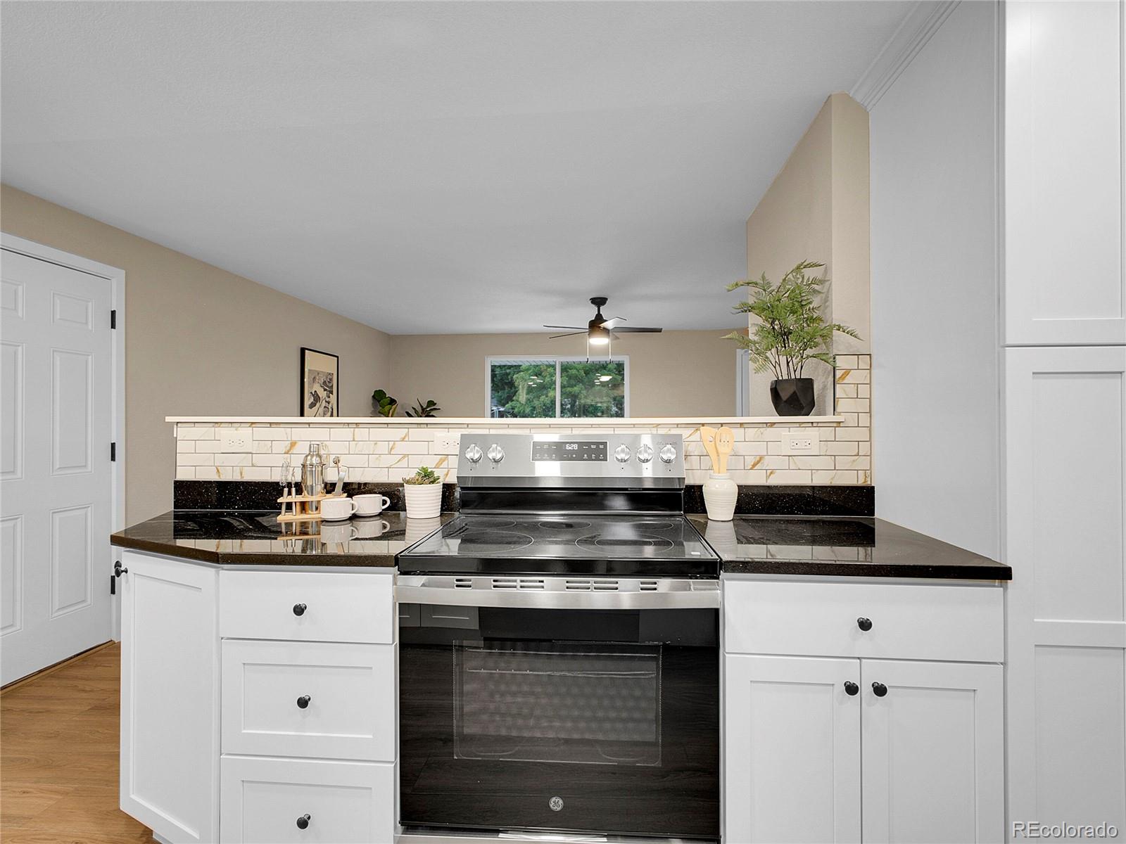 215 East Panama Drive Centennial, CO 80121 - Photo 13 of 50 a kitchen with granite countertop a stove and cabinets