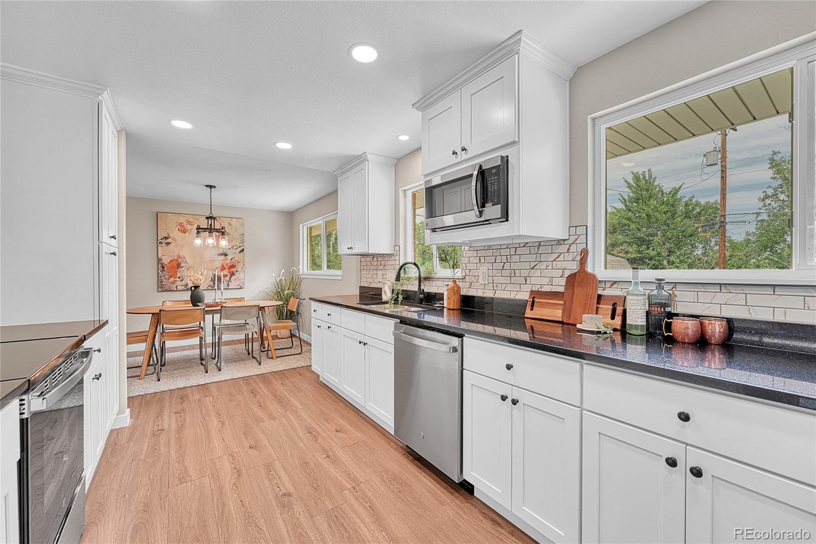 215 East Panama Drive Centennial, CO 80121 - Photo 23 of 50 a large white kitchen with stainless steel appliances granite countertop a lot of counter space and a wooden floors