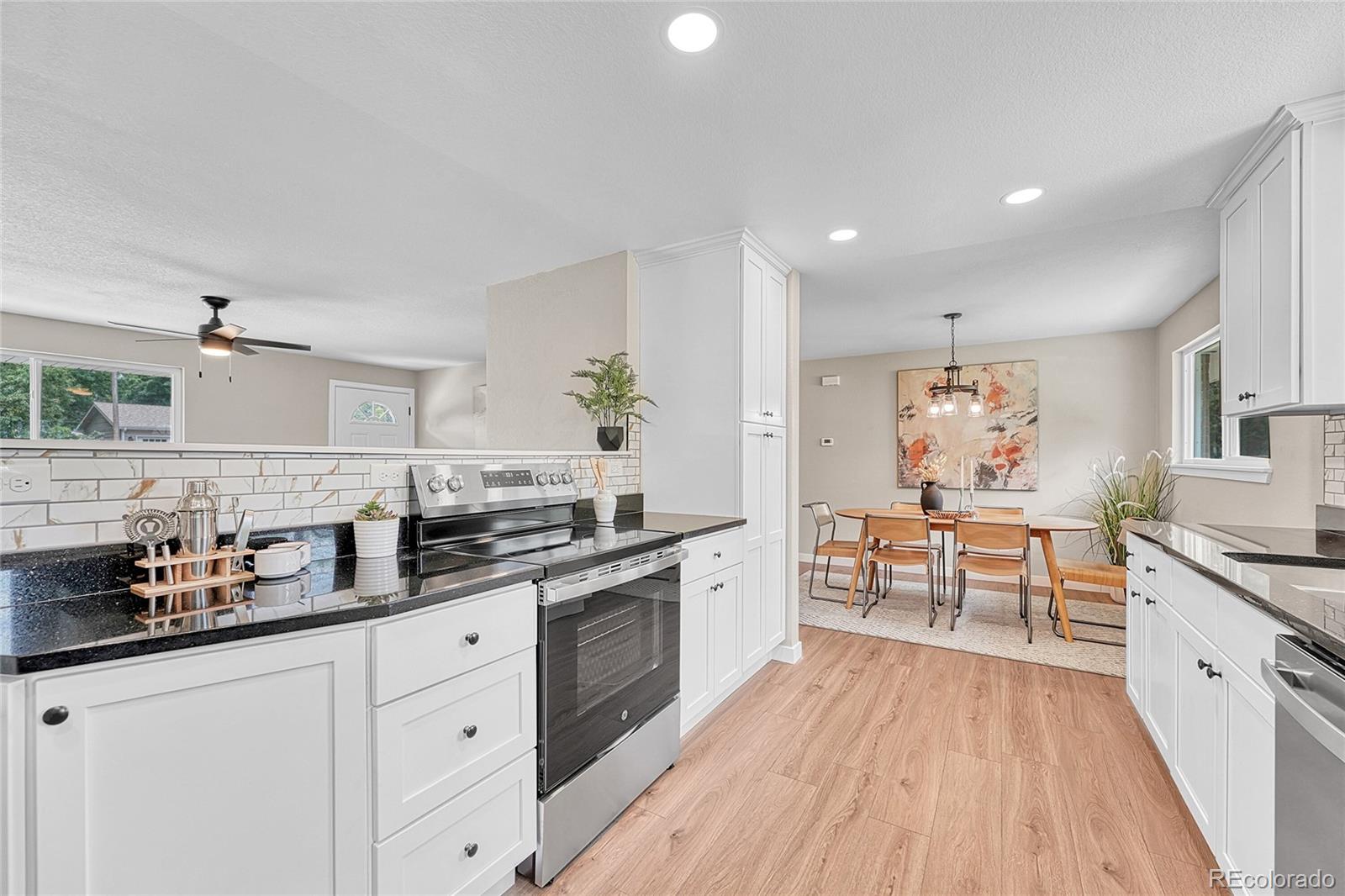 215 East Panama Drive Centennial, CO 80121 - Photo 24 of 50 a large kitchen with stainless steel appliances a lot of counter space and wooden floors