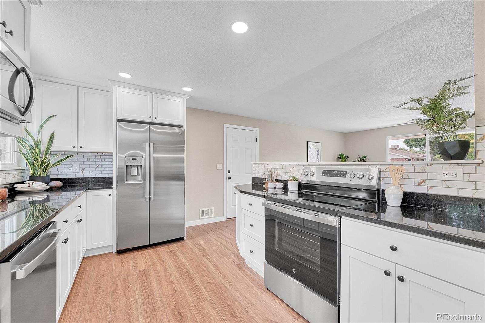 215 East Panama Drive Centennial, CO 80121 - Photo 25 of 50 a kitchen with stainless steel appliances white cabinets and a stove top oven