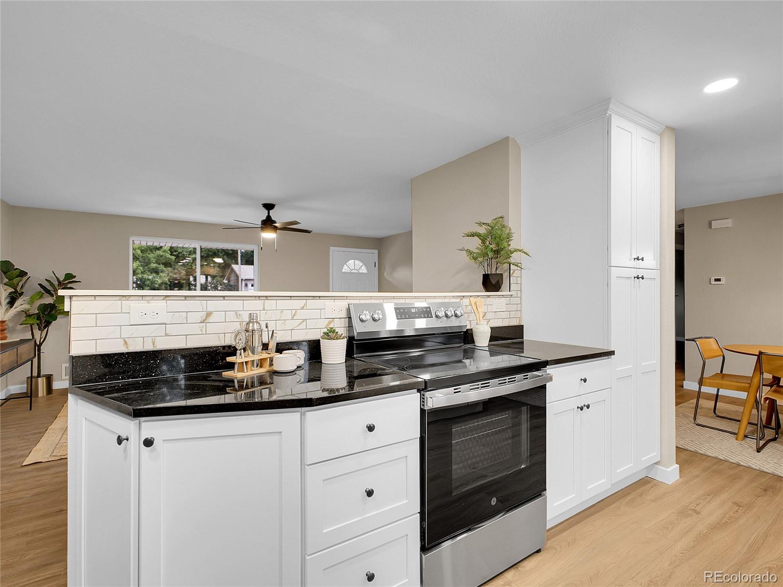215 East Panama Drive Centennial, CO 80121 - Photo 7 of 50 a kitchen with stainless steel appliances a stove a sink and white cabinets