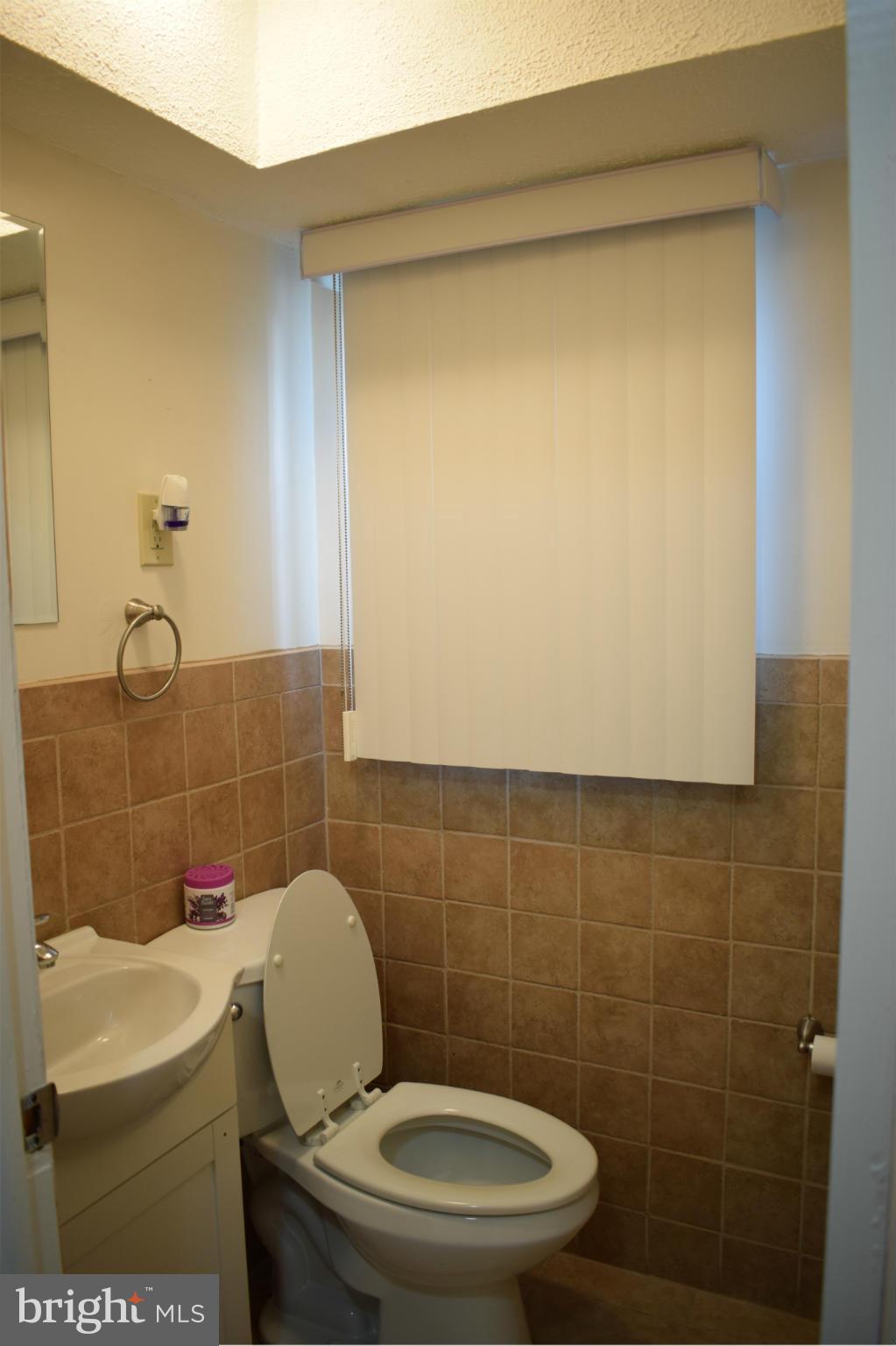 1902 Brookdale Road Windsor Mill, MD 21244 - Photo 5 of 13 a bathroom with a sink a toilet and a mirror