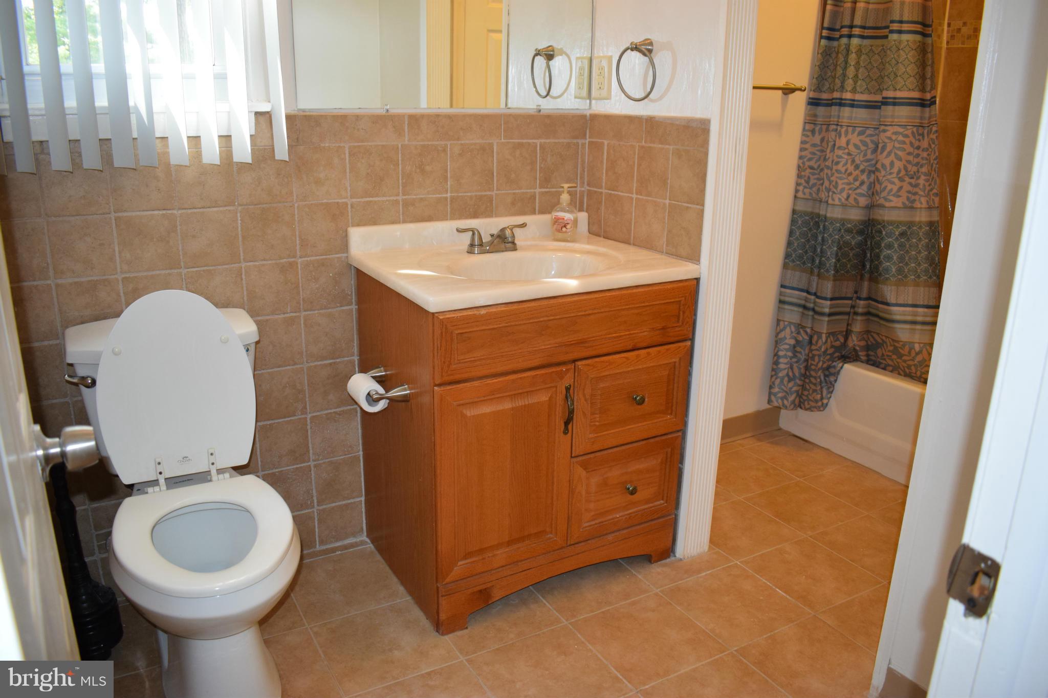 1902 Brookdale Road Windsor Mill, MD 21244 - Photo 7 of 13 a bathroom with a sink a toilet and shower