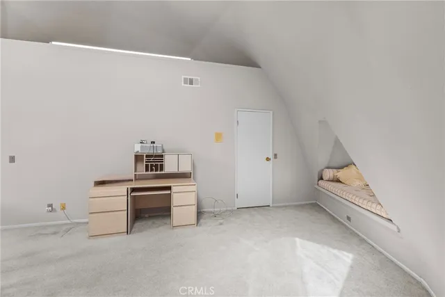 a spacious bedroom with a bed and a dresser in it