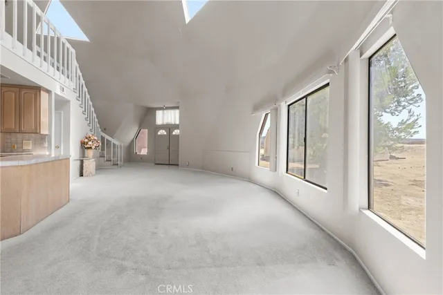 a view of an empty room with a fireplace and windows