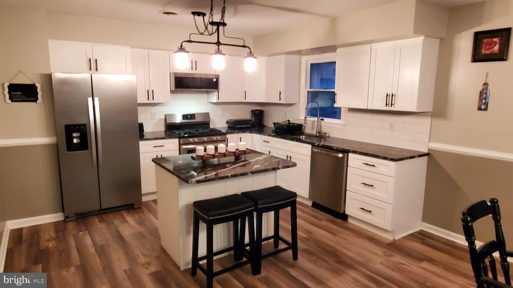 916 Timber Lane Reading, PA 19608 - Photo 6 of 29 a kitchen with stainless steel appliances granite countertop a stove a sink dishwasher a refrigerator and wooden floor