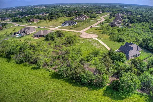 an aerial view of residential houses with outdoor space and trees