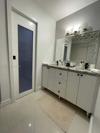 a bathroom with a double vanity sink and a mirror