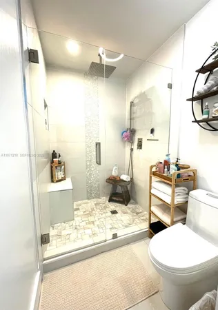 a bathroom with a granite countertop sink mirror vanity and toilet