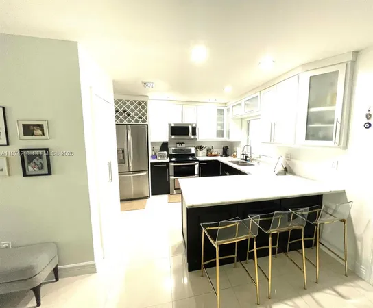a kitchen with kitchen island a dining table and chairs