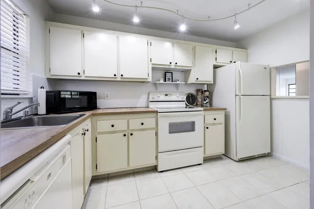 a kitchen with cabinets stainless steel appliances and sink