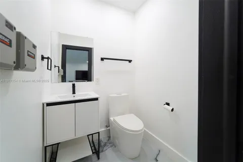 a bathroom with a toilet a sink and mirror