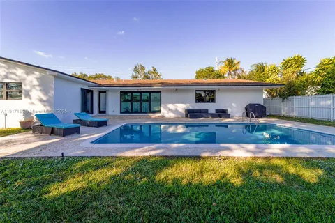a view of house with yard outdoor seating and swimming pool
