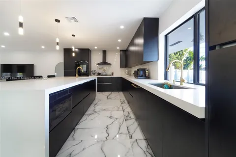 a large white kitchen with a large window